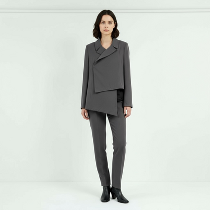 Model wearing asymmetric charcoal tailored jacket with layered front design